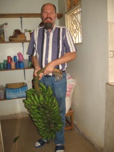 Mark with a bunch of Matooke (cooking bananas)